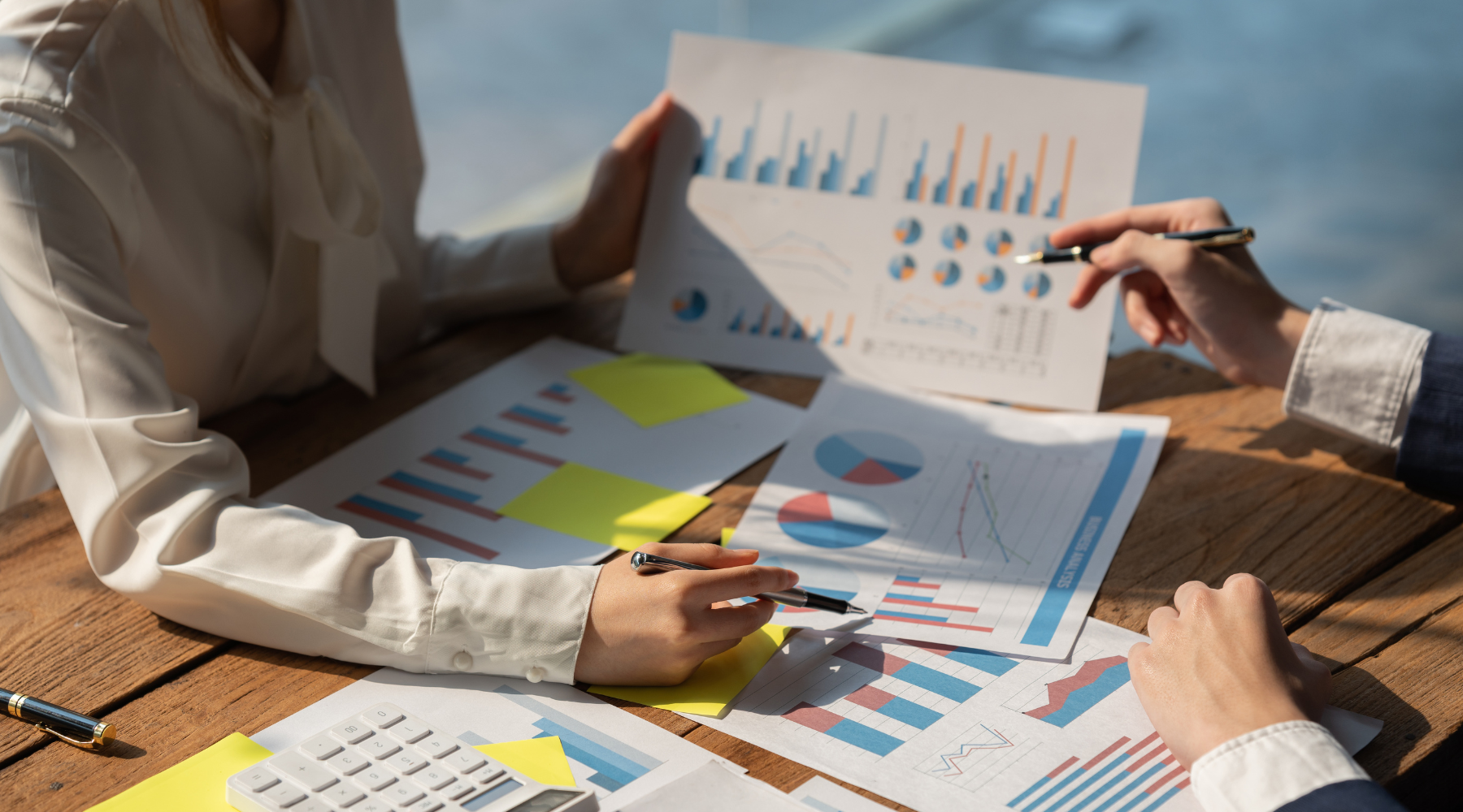 Two professionals reviewing charts and graphs during a business growth planning session